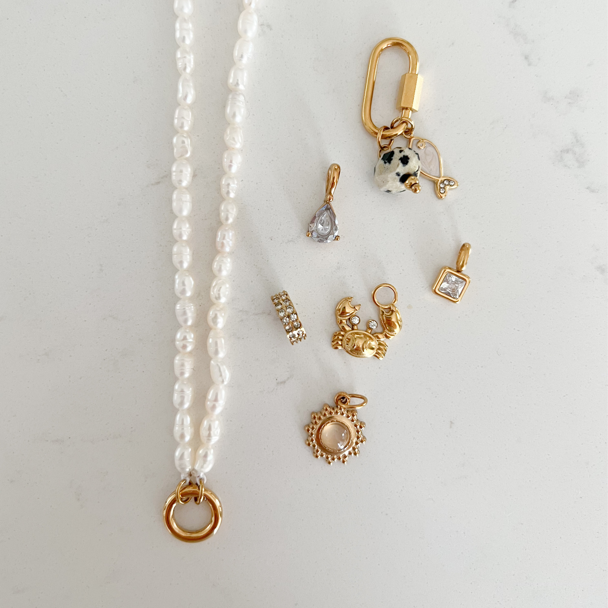The Charm Bar – Hochwertiger, personalisierbarer Schmuck aus 18K PVD vergoldetem 316L Edelstahl. Wasserfeste Halsketten, Charms und Armbänder für einzigartige Kombinationen – jeder Charm erzählt deine Geschichte. Perlen Kette. Perlen Charms. Pearl Necklace.