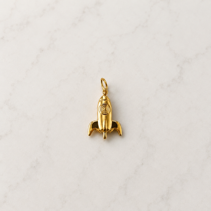 Ein verspielter goldener Raketen-Charm für alle, die gross träumen und hoch hinaus wollen. Die kleine Rakete steht für Mut, Neuanfang, Abenteuer und den Glauben daran, dass alles möglich ist. Ein besonderer Charm mit funkelnder Symbolik – perfekt für deine persönliche Charm-Kombination oder als kleines Geschenk mit Bedeutung.