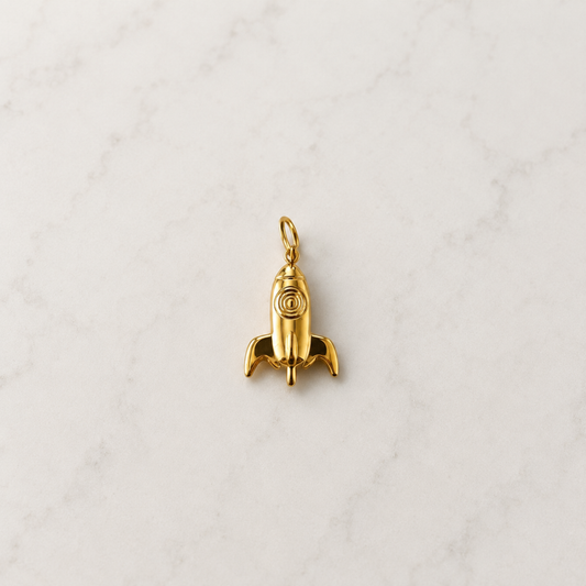 Ein verspielter goldener Raketen-Charm für alle, die gross träumen und hoch hinaus wollen. Die kleine Rakete steht für Mut, Neuanfang, Abenteuer und den Glauben daran, dass alles möglich ist. Ein besonderer Charm mit funkelnder Symbolik – perfekt für deine persönliche Charm-Kombination oder als kleines Geschenk mit Bedeutung.